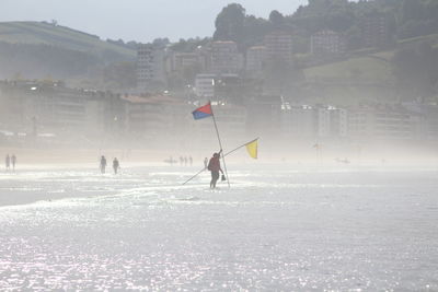 People skiing on snowcapped mountain against sky