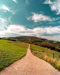 Empty road along countryside landscape