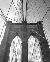 Low angle view of suspension bridge against sky