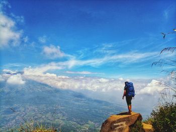 Man standing on mountain against sky