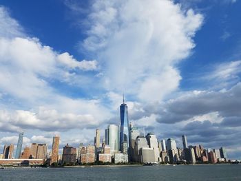 Modern buildings in city against cloudy sky