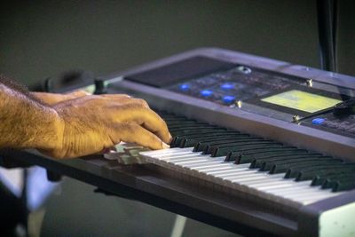 Cropped hands of musician playing piano in nightclub