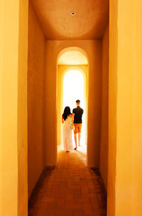 Rear view of people standing in corridor of building