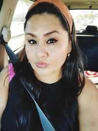 Portrait of beautiful young woman in car