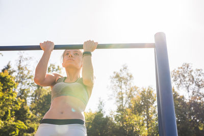 Rear view of woman exercising on field