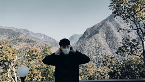 Man standing on mountain against sky