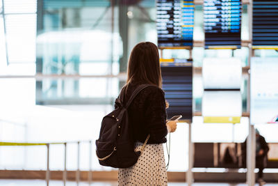 Rear view of woman standing in corridor