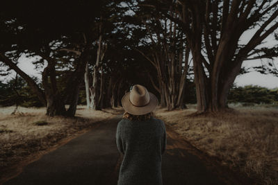 Rear view of woman standing on road