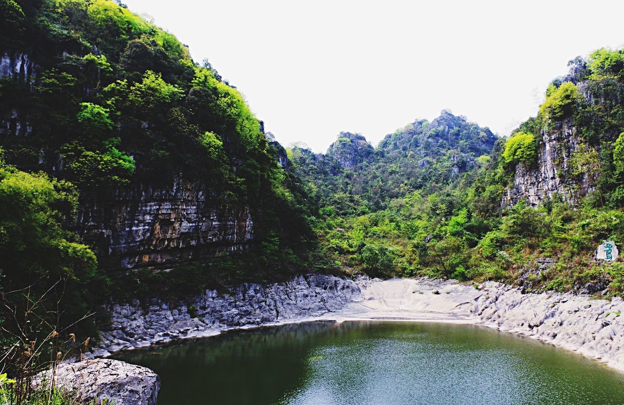 tree, water, clear sky, tranquil scene, tranquility, scenics, beauty in nature, nature, reflection, green color, growth, lake, waterfront, mountain, river, lush foliage, idyllic, forest, day, green