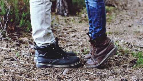 Low section of couple standing on field