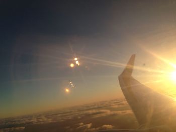 Close-up of airplane wing against sky during sunset