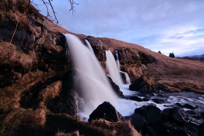 Scenic view of waterfall against sky