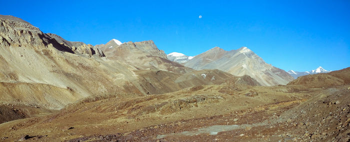 Panoramic view of rocky mountains against clear blue sky