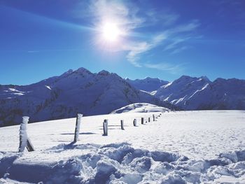 Scenic view of snow covered mountains against sky on sunny day