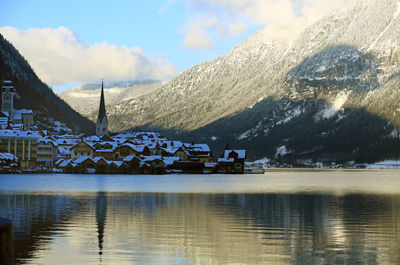 Houses and snowcapped mountain by river