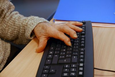 Cropped image of senior woman hand on keyboard