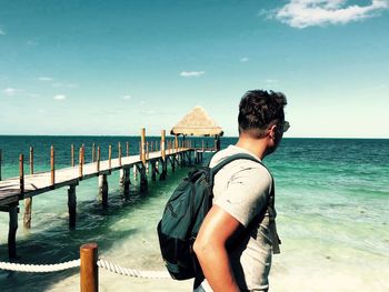 Rear view of man looking at sea against sky