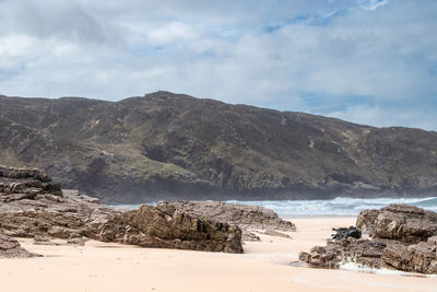 Scenic view of sea and mountains against sky