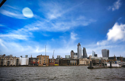 River by buildings against sky in city