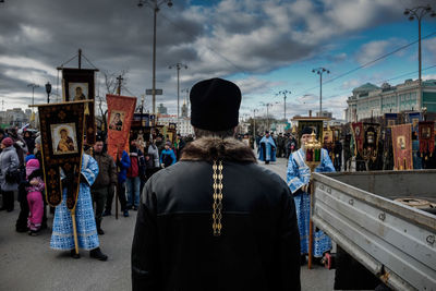 Rear view of people standing on street in city