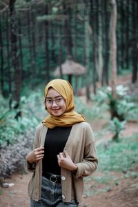 Young woman using smart phone in forest