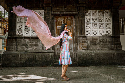 Rear view of woman standing against building