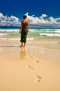 Full length of boy on beach against sky