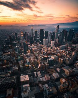 Aerial view of buildings in city during sunset