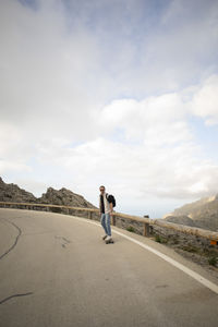 Mature man skateboarding on road against sky