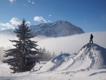 Man standing on snowcapped mountain against sky