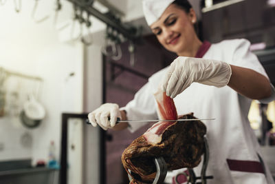 Woman cutting mean in shop