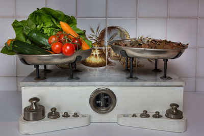 Close-up of coins and various vegetables on weight scale