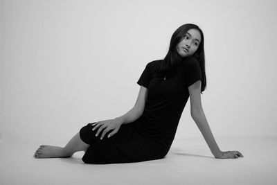 Portrait of young woman against white background