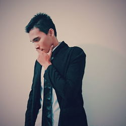 Young man standing against white background