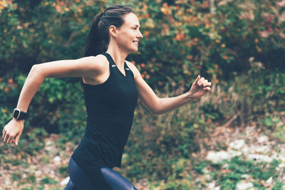 Portrait of young woman exercising on field