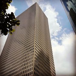 Low angle view of modern building against cloudy sky