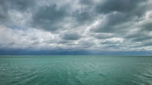 Scenic view of sea against storm clouds