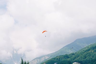 Low angle view of person paragliding against sky