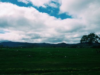 Countryside landscape against cloudy sky