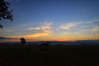 Silhouette field against sky during sunset