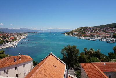 High angle view of town by sea against clear sky