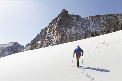 Man walking on snow in front of mountains