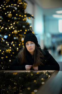 Portrait of young woman in illuminated room