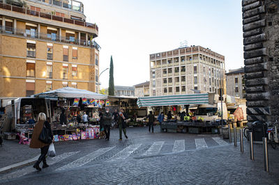 People walking on street against buildings in city