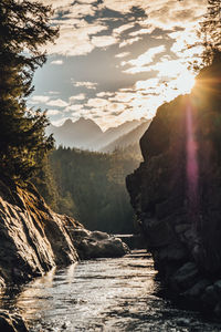 Scenic view of river amidst mountains against sky