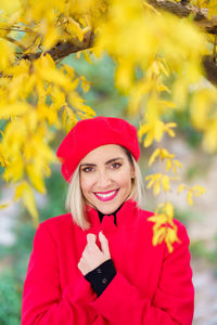 Portrait of young woman standing against plants