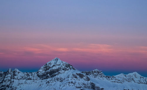 Scenic view of snowcapped mountains against sky during sunset