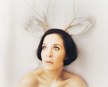 Young woman wearing antler headband while looking away