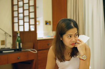 Close-up of young woman playing cards game at home