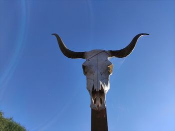 Low angle view of statue against clear blue sky